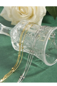 Detail von Gold- und Silberschlangen-Gliederketten mit Perlen auf Vintage-Glas
