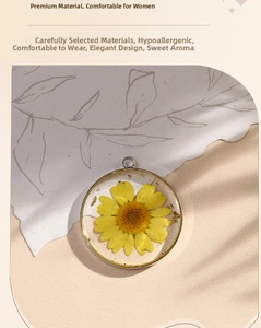 Detail view of handmade resin pendant with yellow daisy and gold foil in silver frame