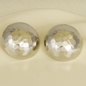 Détail macro de boucles d'oreilles dôme argentées avec texture martelée artisanale