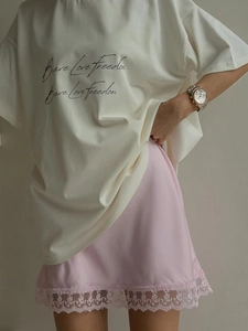 Close-up of pink satin skirt with exquisite wide lace hem and soft texture details
