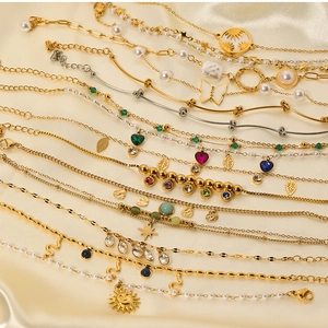 Flat lay of vintage gold and silver bracelets with pearls and zircons on beige silk