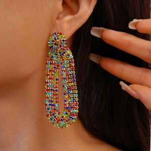 Close-up of model wearing geometric gold earrings with colorful zircon rhinestones