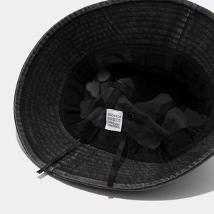 Detailed macro view of inner stitching and 100% cotton wash label on denim bucket hat