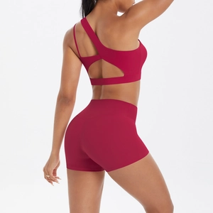 Deep red two-piece yoga set with cross-back sports bra and high-waisted gym shorts detail