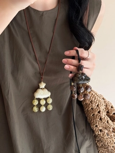 Vue détaillée des pendentifs nuages et étoiles avec pompons en beige et marron foncé