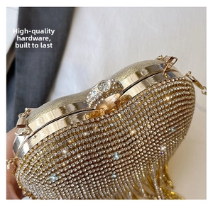Close-up of golden evening clutch with sparkling rhinestones and crystal ring clasp