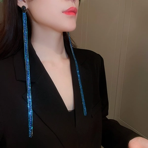 Long blue rhinestone chain tassel earrings worn by a model in a professional side view