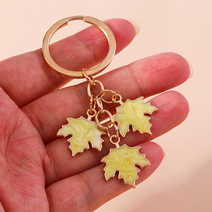 Close-up of golden keychain with three yellow marble-patterned ginkgo leaf pendants