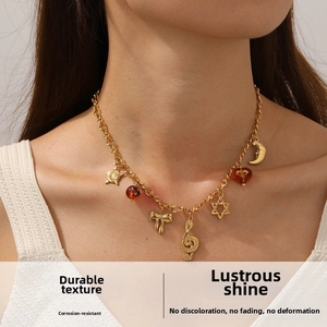 Close-up of gold plated stainless steel necklace with star, moon and music note charms