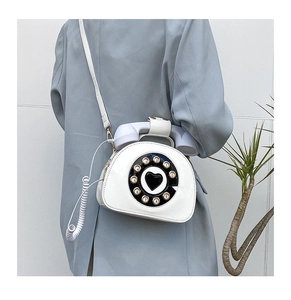 White retro telephone shaped shoulder bag with creative dial and spring cable detail on model