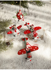 Close-up of iron Christmas aircraft ornaments with Santa and Reindeer on a snowy backdrop