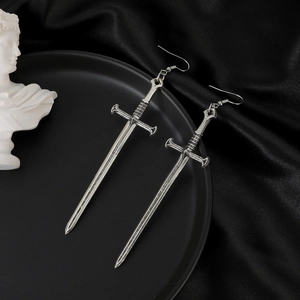 Detail of vintage silver sword earrings displayed on black silk and white sculpture