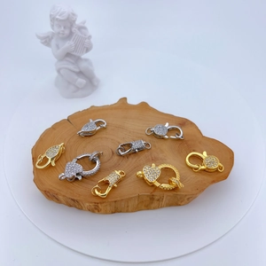 Detailed view of gold and silver heart-shaped lobster clasps with pavé cubic zirconia