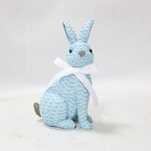 Close-up of light blue resin rabbit statue with woven texture and white ribbon bow