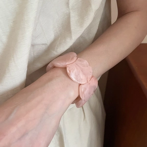 Detailed view of pink marble texture acrylic chain bracelet on a model's wrist