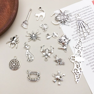 Macro shot of 15 antique silver Halloween charms including spider, skull and pumpkin shapes
