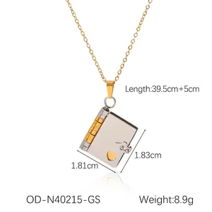 Detailed view of 18K gold-tone book pendant with heart cutout and product dimensions