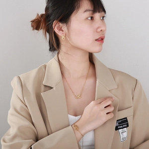 Golden titanium steel infinity necklace, bracelet and earrings jewelry set on model