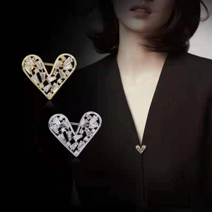 Detail of heart brooch with rhinestones showing front design and on-collar wear