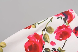 Détail macro d'un imprimé floral de roses rouges sur un tissu d'été de couleur crème