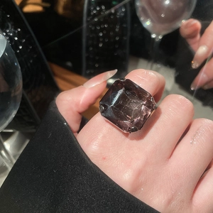 Macro shot of a large square-cut purple gemstone ring with four-prong silver setting