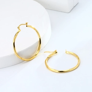 Detailed macro view of gold-plated hollow twisted hoop earrings in 925 sterling silver