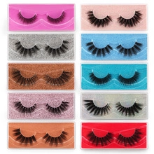 Detailed flat lay of ten pairs of 3D faux mink eyelashes in colorful glitter storage boxes