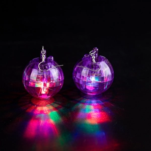 Close-up of disco ball earrings with colorful LED lights reflecting on dark surface