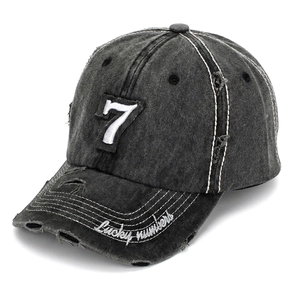 Close-up of number 7 embroidery and frayed edges on washed vintage denim baseball cap