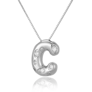 Macro shot of silver letter C pendant with micro-set zircon stones and fine chain