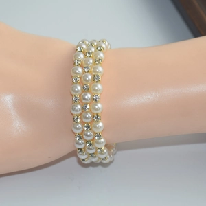 Detailed view of triple-layered bracelet with white pearls and sparkling rhinestones