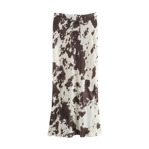 Détail de jupe longue à imprimé vache marron et blanc, texture soie et ceinture fine