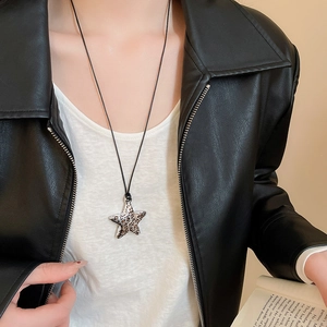 Detail of star-shaped pendant with leopard print pattern and black cord necklace