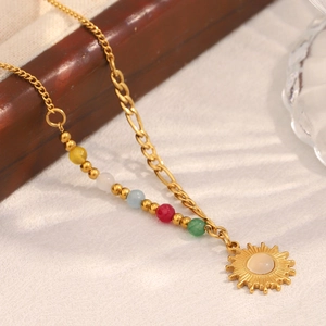 Close-up of gold sun pendant necklace with natural stone and multi-color beads