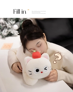 Close-up of cute plush cat toy with red apple decor and fine embroidery in home setting