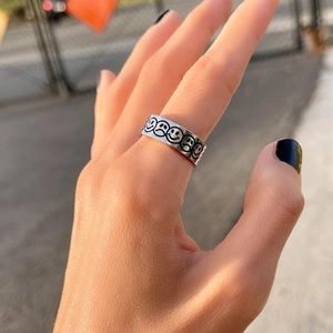 Detailed close-up of titanium steel ring with engraved smiling and crying face emojis