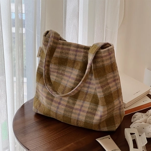 Gros plan d'un sac cabas en laine à carreaux rétro avec étiquette de marque