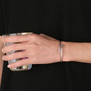 Close-up of silver twisted cable nail bracelet worn in a casual lifestyle setting