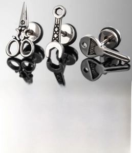 Macro detail of silver titanium steel earrings in wrench and key tool designs