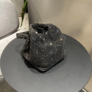 Close-up of black rhinestone bucket bag with crystal knots and silver handle details