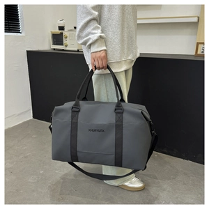 Side view of large grey oxford cloth travel bag showing adjustable shoulder strap and handles