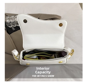 Detailed internal view of white saddle bag showing gold magnetic closure and compartments