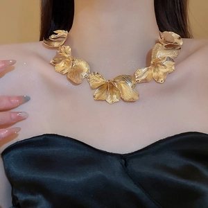 Close-up of a gold floral tassel statement necklace with realistic petal textures