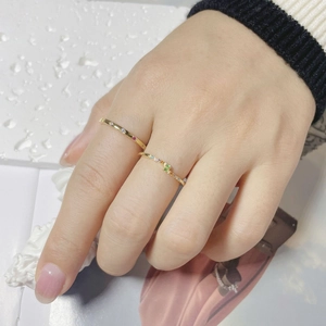 Close-up of gold S925 silver stacked rings with colorful cubic zirconia on finger