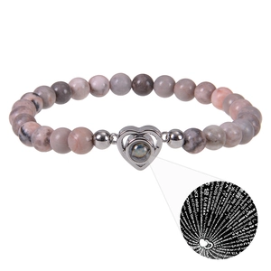 Detail of heart projection stone on pink zebra stone beaded bracelet for couples