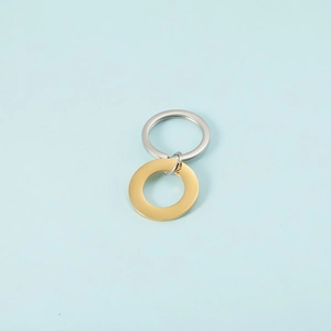 Polished stainless steel gold pendant and silver keychain ring on blue background