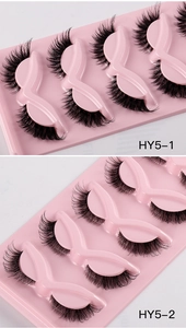 Macro detail of dense fox-style false eyelashes with clear bands in pink bow packaging