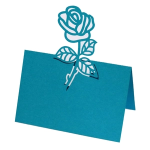 Macro view of peacock blue laser-cut rose hollow place card for wedding tables