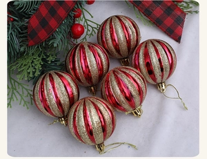 Detail of 6cm red and gold striped Christmas balls with glitter and festive pine branches