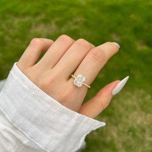 Detail of S925 silver ring with radiant cut zircon and gold plating on a finger